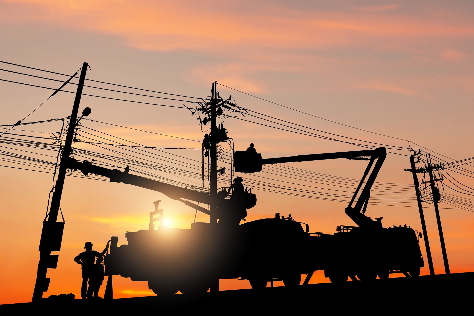 Silhouette of Electrician officer climbs a pole and uses a cable car to maintain a high voltage line system, Shadow of Electrician lineman repairman worker at climbing work on electric post power pole